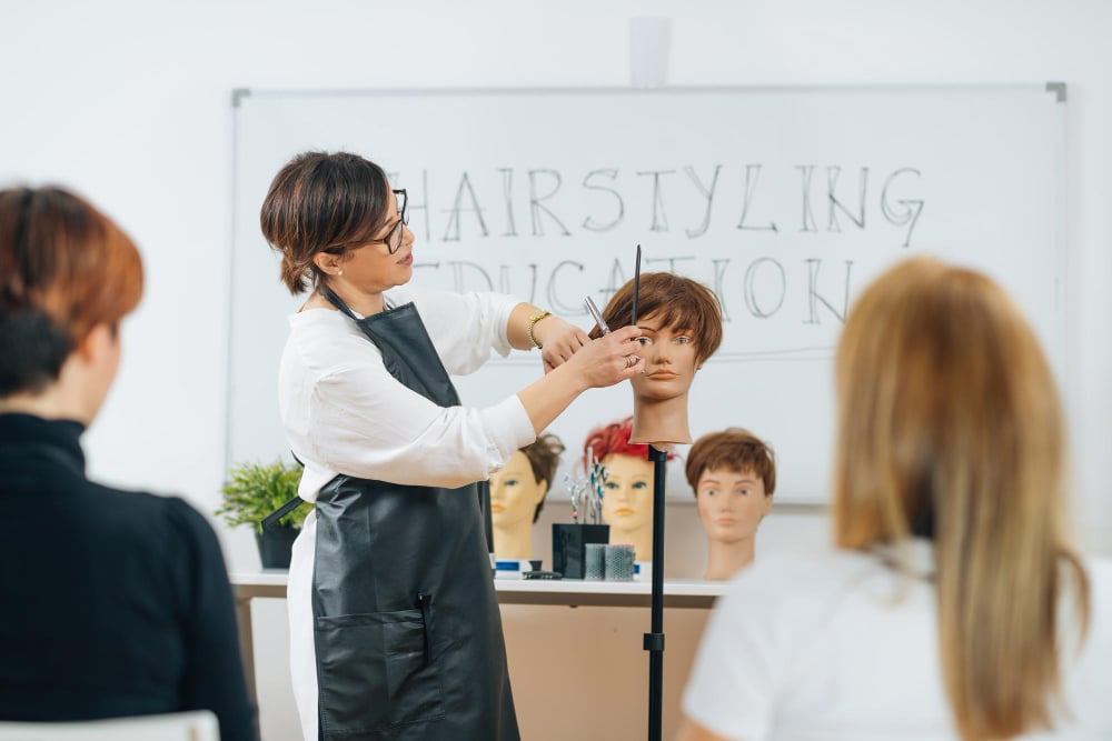 Cosmetology teacher demonstrating for students