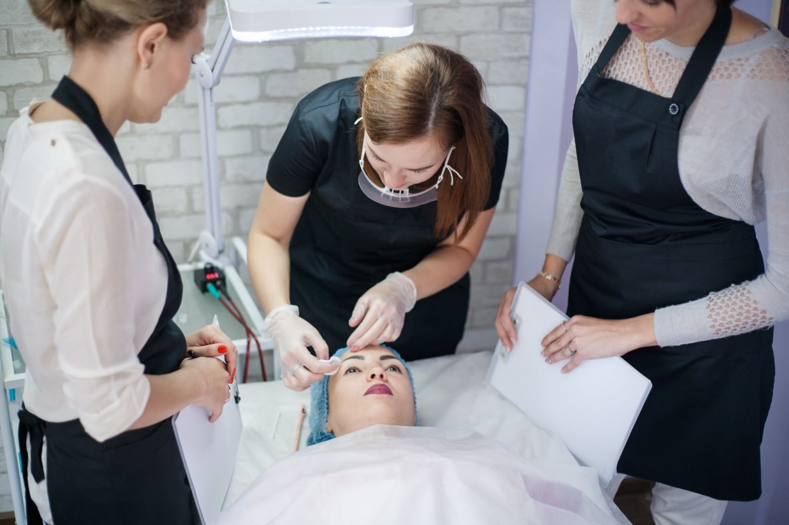 Professional esthetician in Chicago applying makeup to a client in a salon setting.