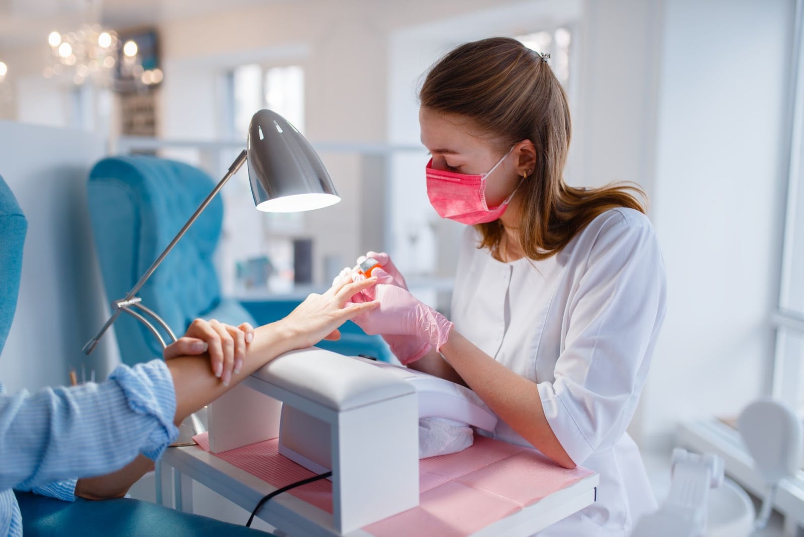 Nail technician working with a customer