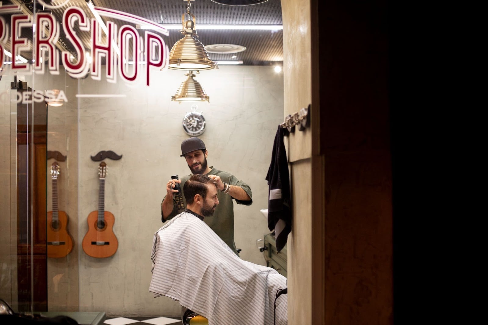 Professional barber using clippers on a customer at a contemporary barbershop