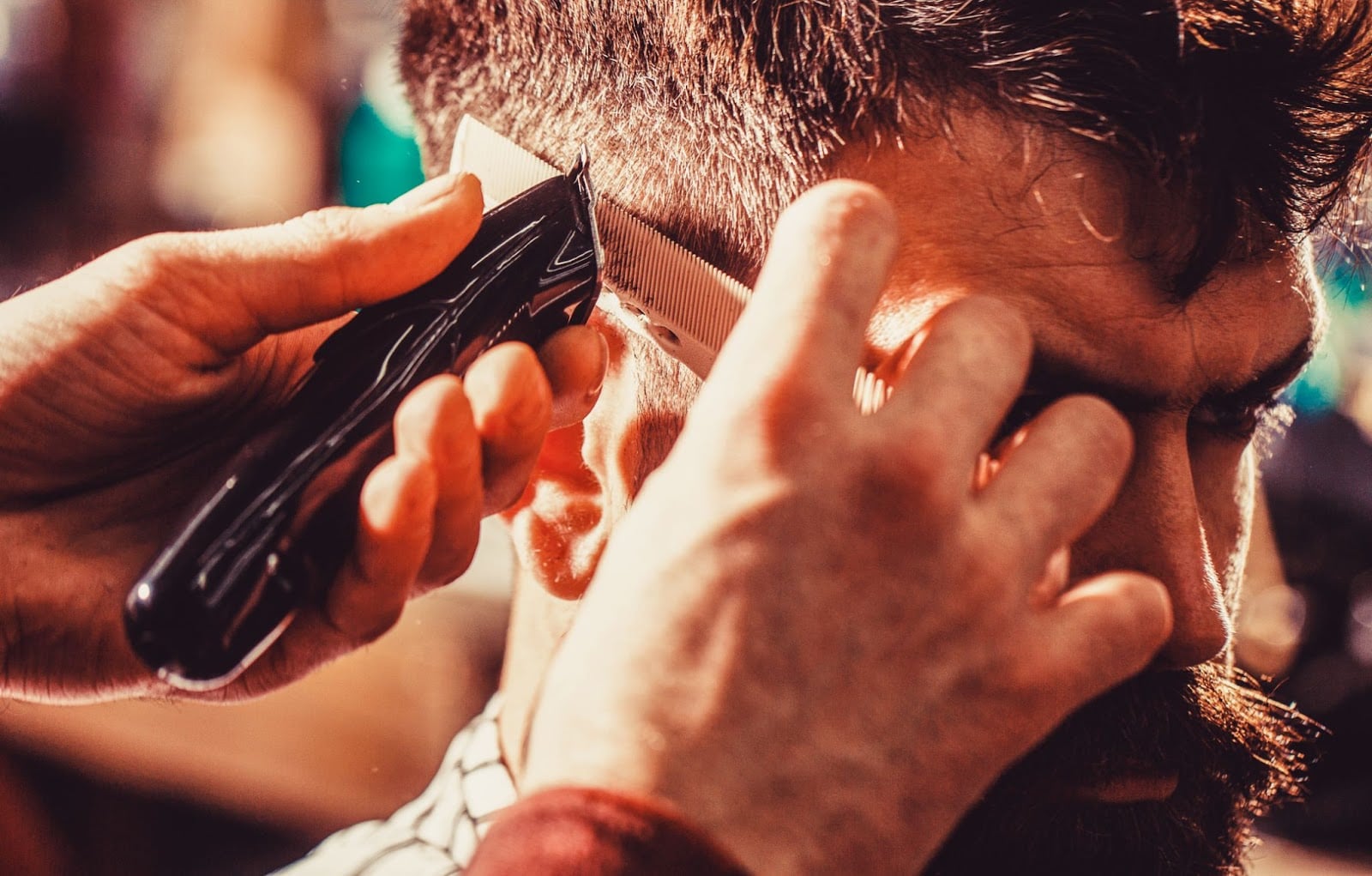 Close-up of barber using clippers and comb for a precise men’s haircut