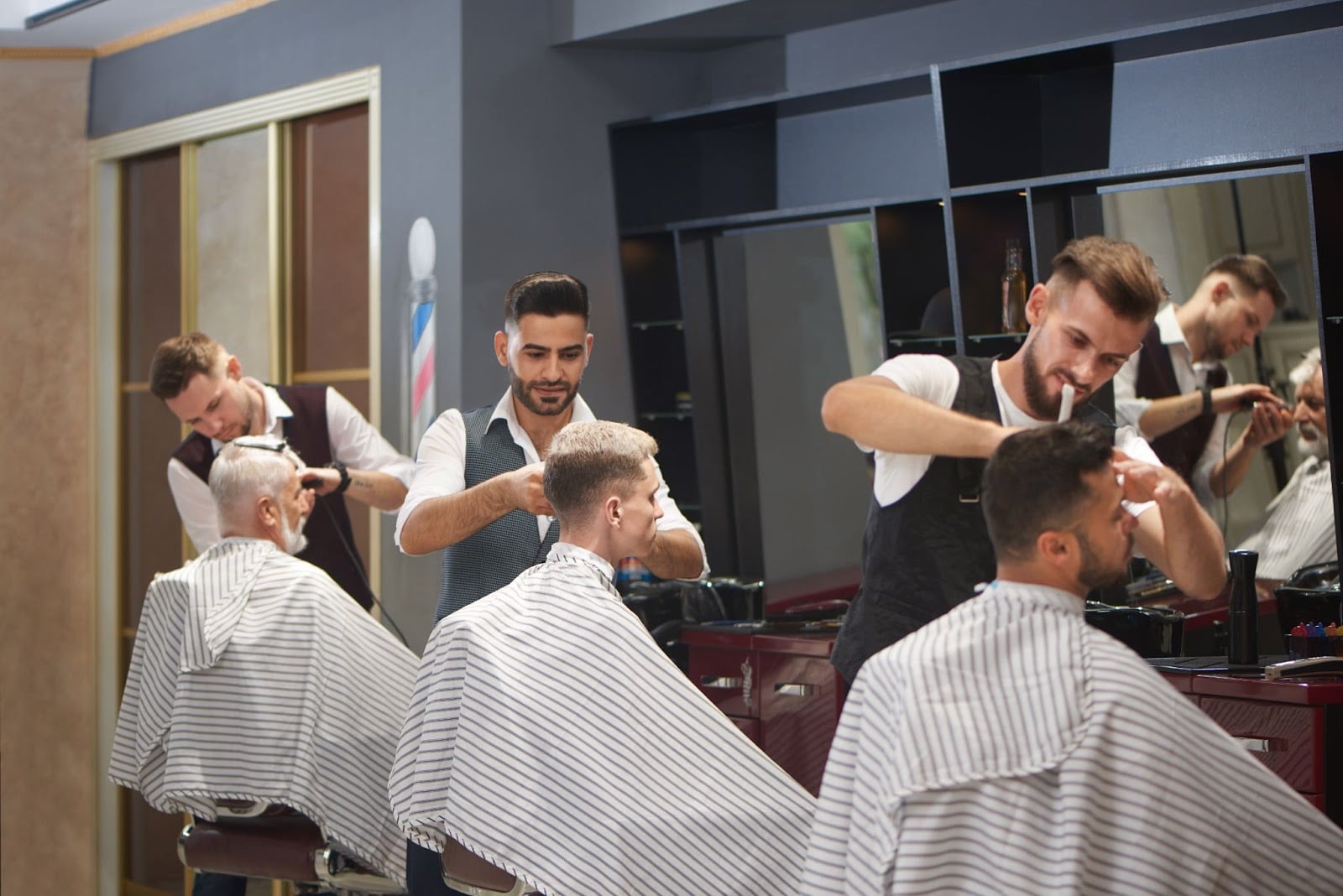 Hairstyling for Men vs. Women: What’s the Difference? 3 Busy barbershop with multiple barbers cutting clients’ hair