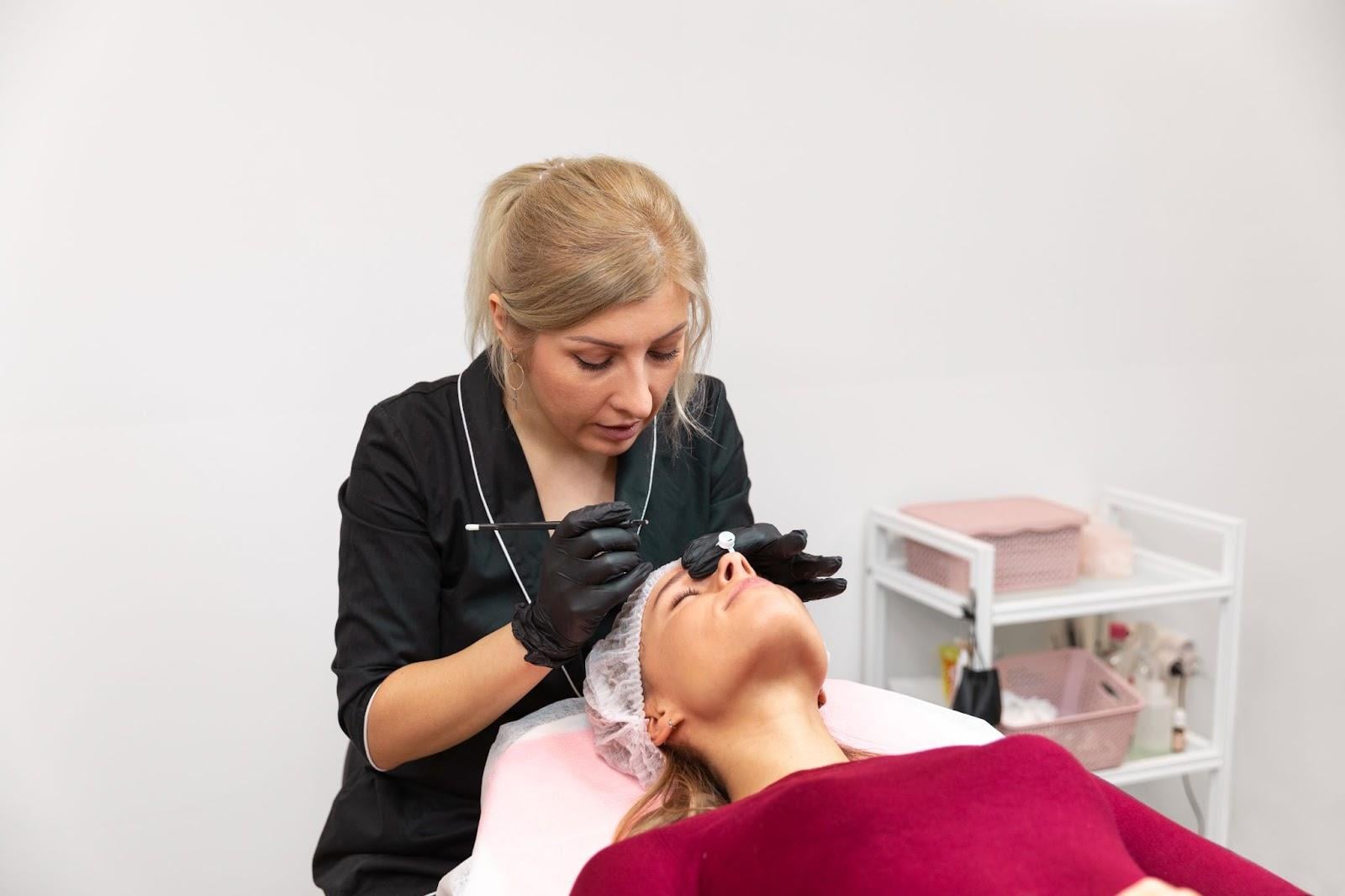 Esthetician performing facial procedure on client in a professional treatment room