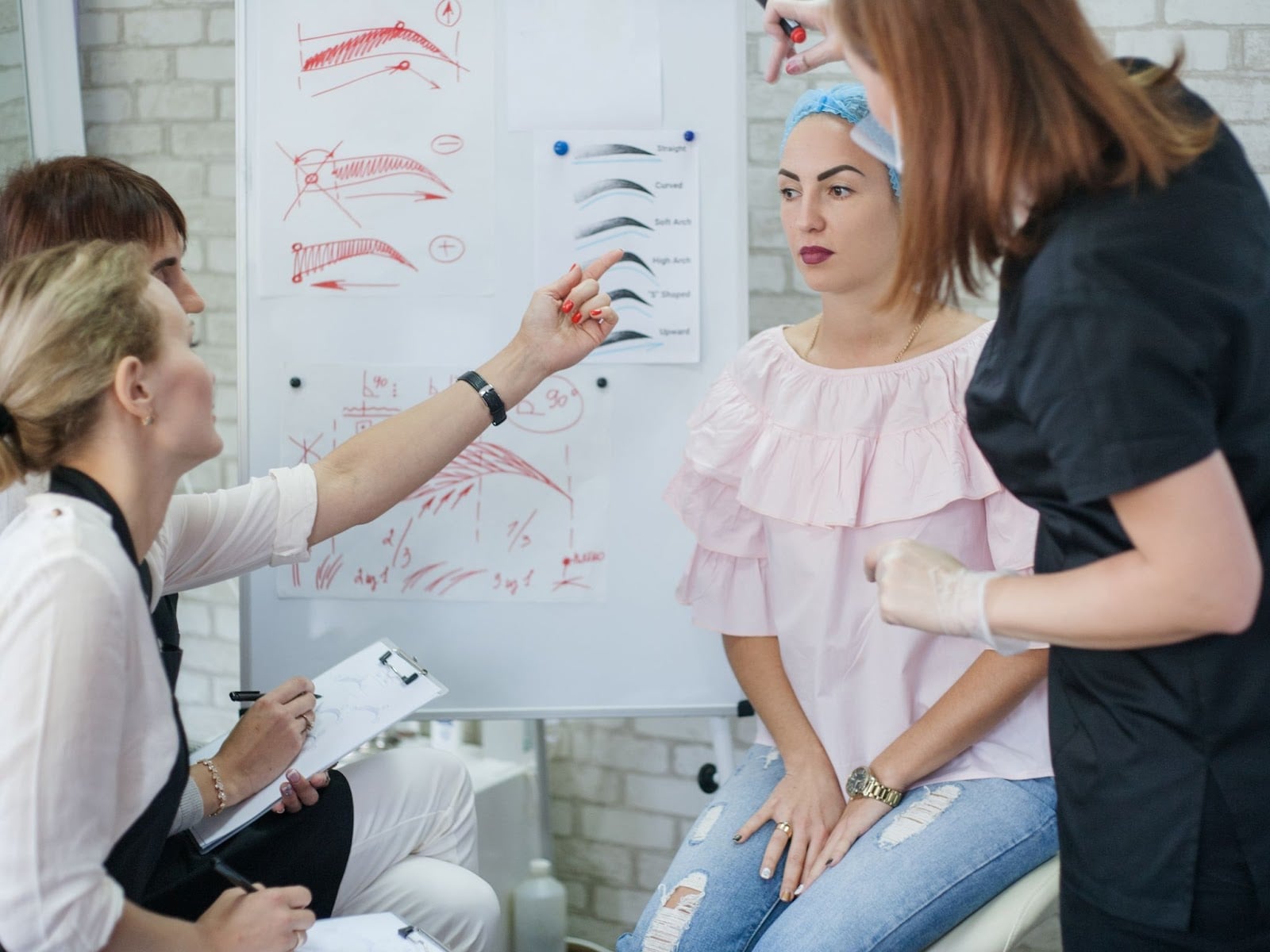Students of different ages checking examples of eyebrow models while working