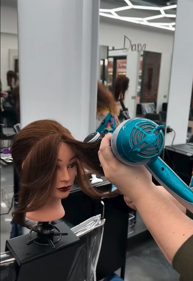 Doing hair dryer on a doll head while training. 
