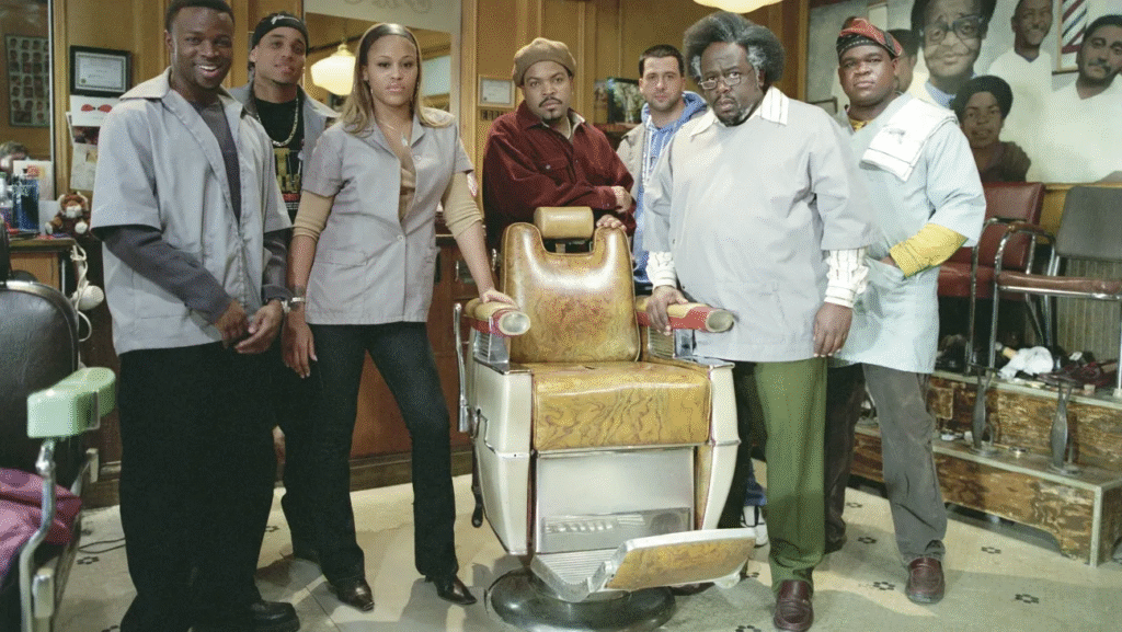 Cast of Barbershop movie standing in a barbershop with vintage barber chair