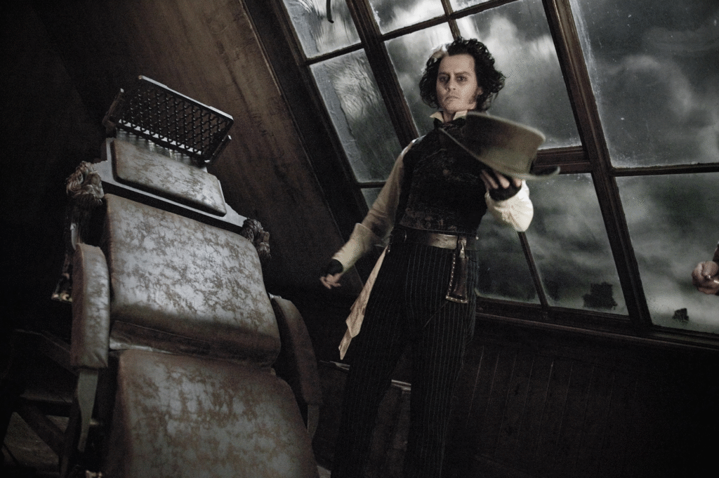 Johnny Depp as Sweeney Todd standing by barber chair in dark film scene