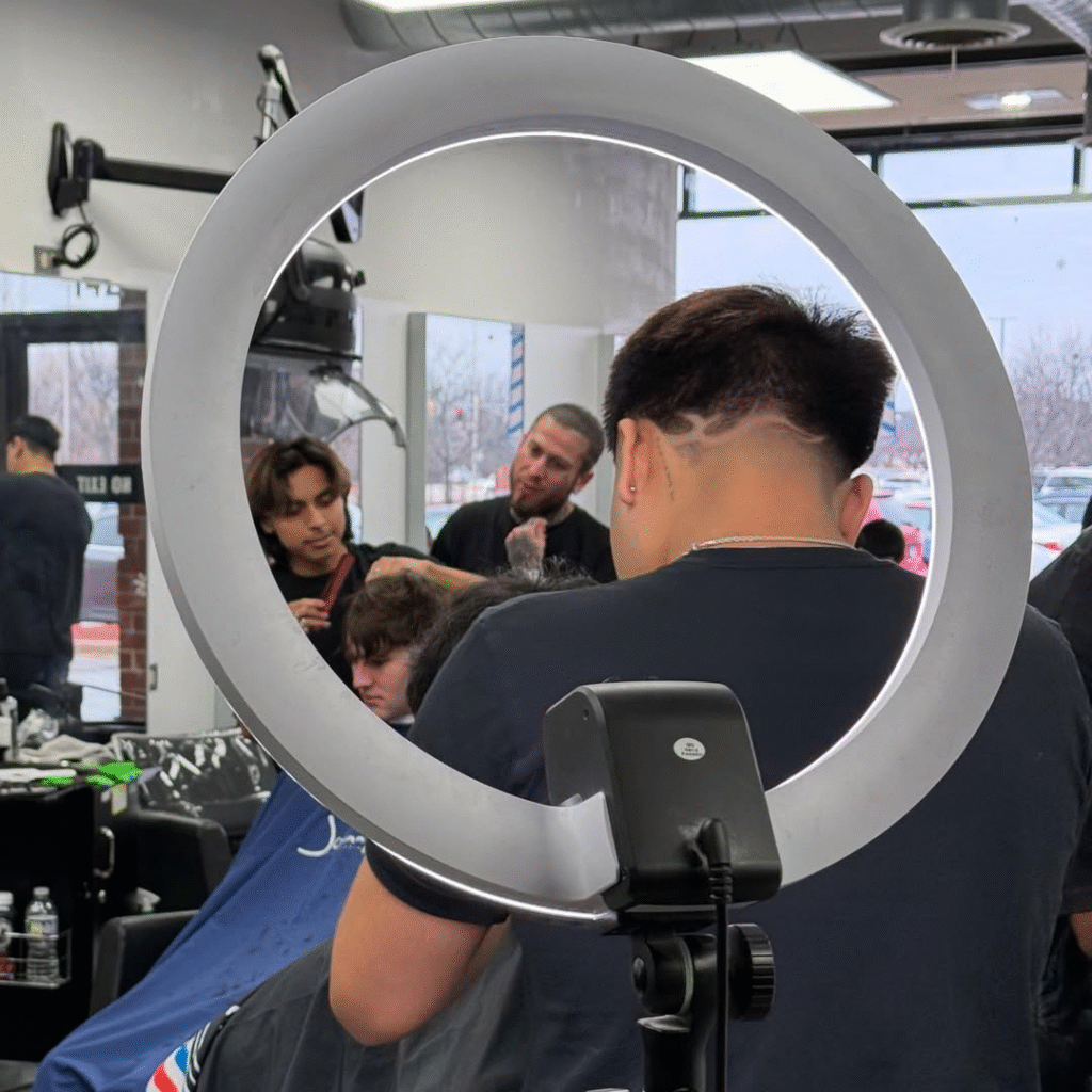 Barber students practicing haircut in Illinois barber school classroom
