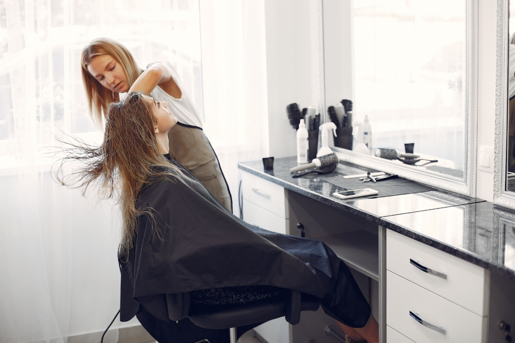Cosmetology student practicing hairstyling techniques during beauty school training.