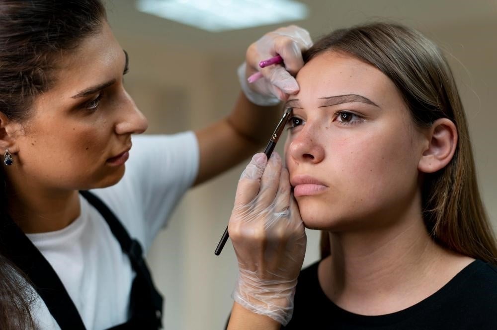 How to Become a Brow Technician: Essential Skills and Certification Guide 1 Brow technician working with a client.