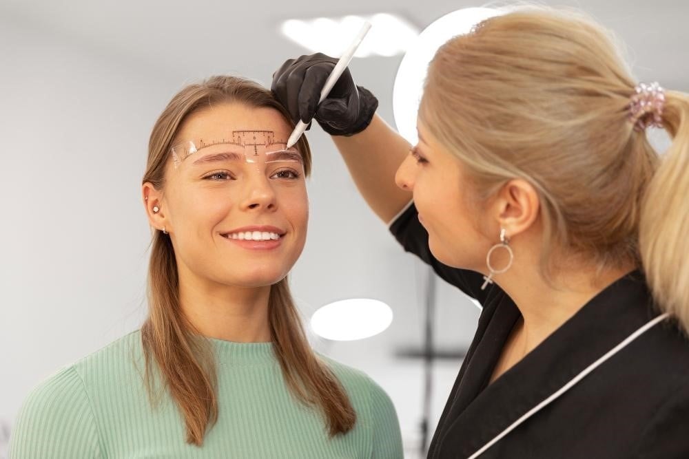 How to Become a Brow Technician: Essential Skills and Certification Guide 2 Certified brow technician working on a client at a salon.
