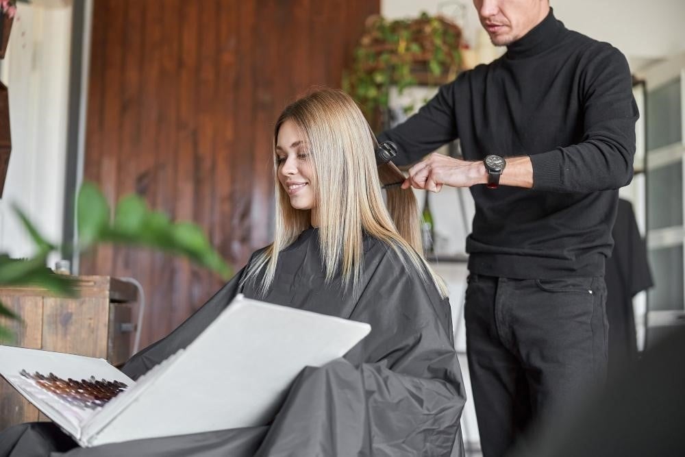 The Top Eight Personality Traits of Successful Hairstylists 5 Hairstylist working on a female client's hair.