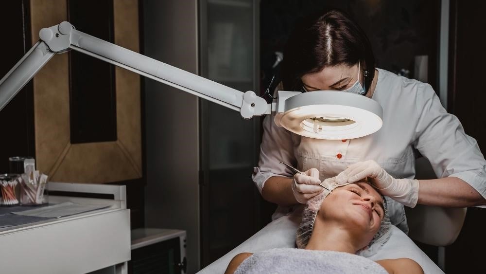 Aesthetician performing skincare treatments on a client.