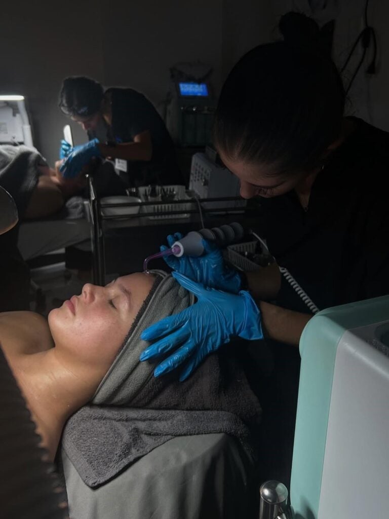 Students performing skincare treatments during their esthetics class at Cosmetology & Spa Academy in Illinois
