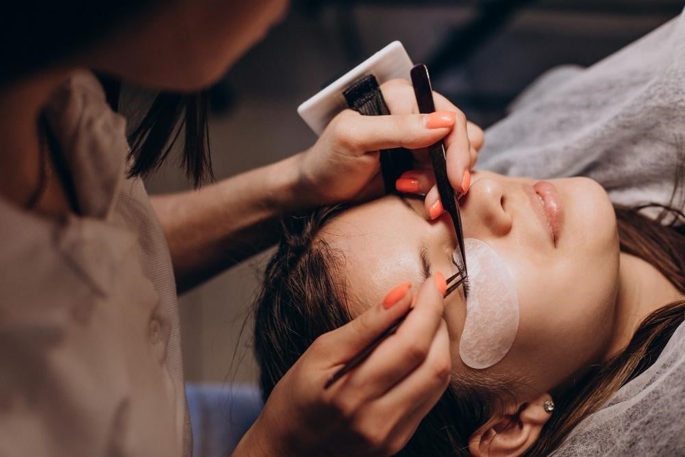 Lash Extension Types Every Cosmetologist Should Know 1 Student at a beauty school practicing lash extensions on a client.