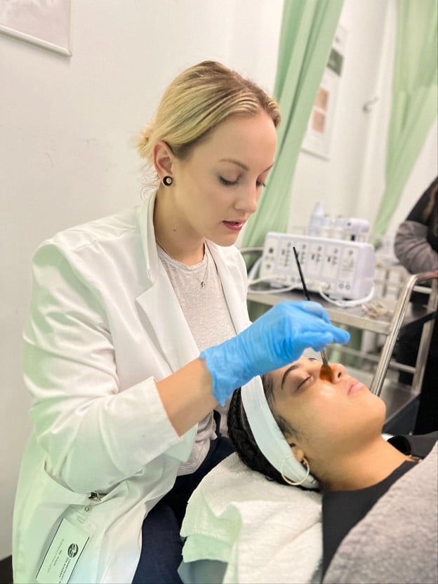 How to Transfer Your Esthetician License to Another State 1 Esthetics student applying professional skincare treatment during hands-on training at Cosmetology & Spa Academy in Illinois.