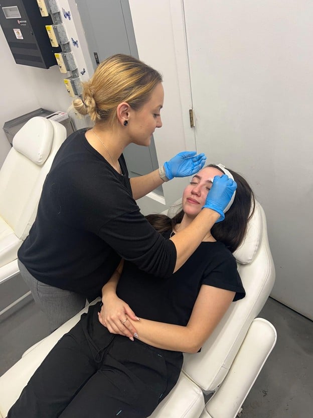 How to Transfer Your Esthetician License to Another State 2 Esthetics student performing a professional facial treatment under instructor supervision at Cosmetology & Spa Academy, esthetics school in Illinois.