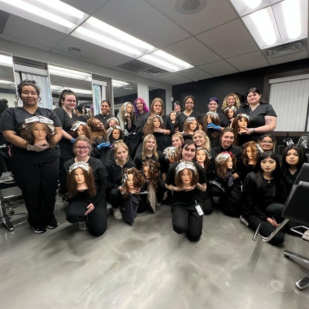 Top 3 Ways to Do Ombre Hair: A Guide for Aspiring Hairstylists 4 Cosmetology students posing with mannequin heads after completing color and ombre hair training at Cosmetology & Spa Academy beauty school in Illinois.