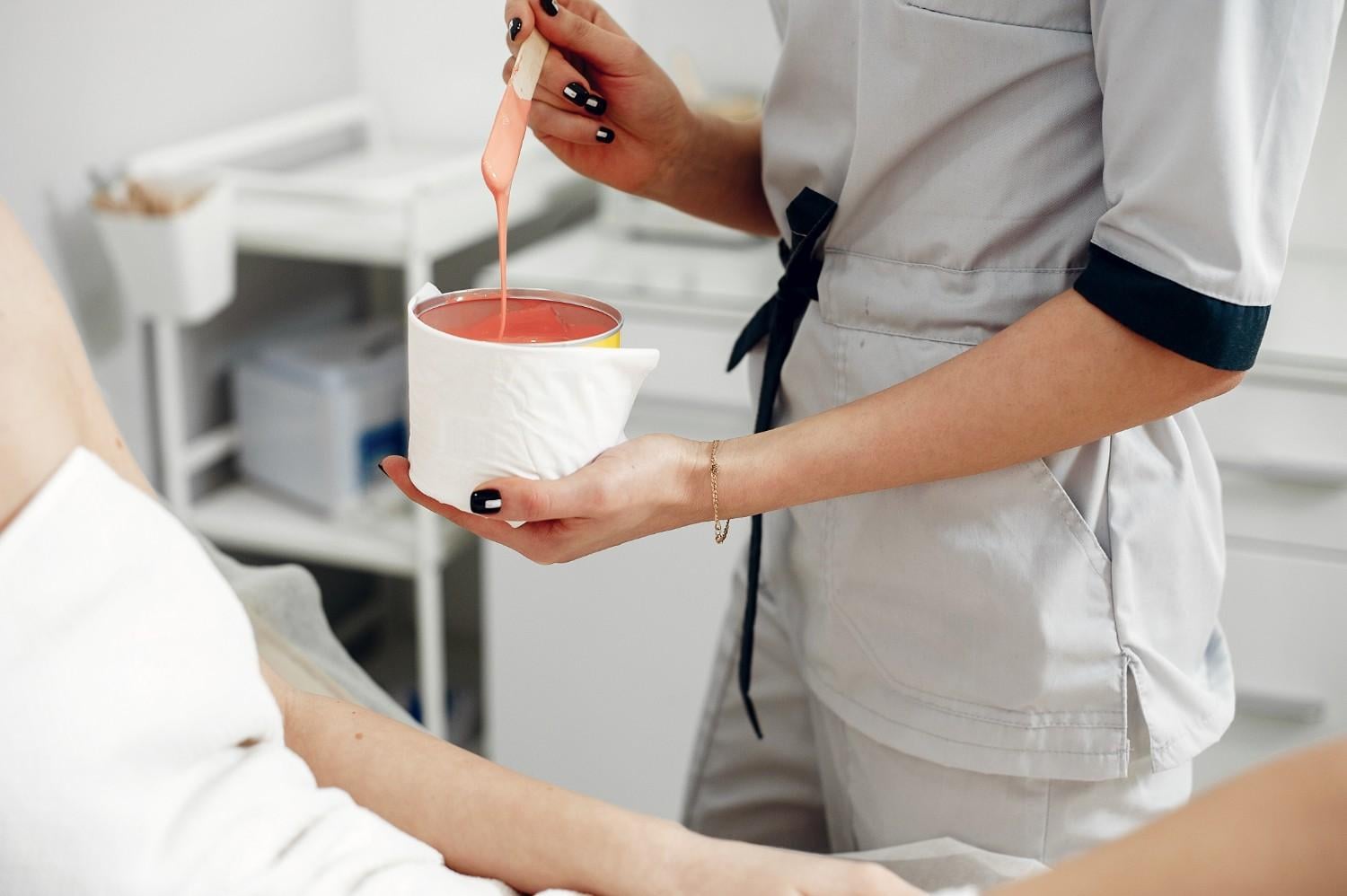 Professional waxing preparation during esthetics training at Cosmetology & Spa Academy, an Illinois beauty school teaching hair removal techniques.
