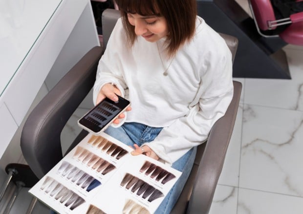 Girl taking a photo of hair colors at cosmetology training school